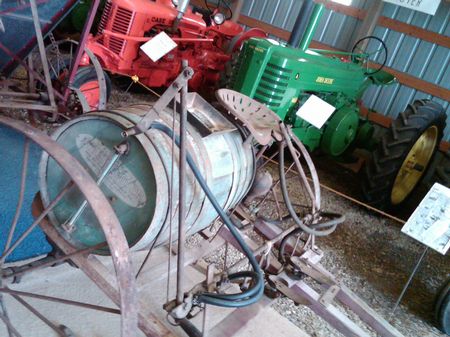 An antique weed sprayer (foreground) and some antique tractors at the South Dakota Tractor Museum in Kimball. (Photo by Seth Tupper)